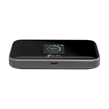 A compact, pocket-sized TP-Link M7750 4G LTE-Advanced MiFi router on a desk, ideal for travel, business trips, and remote work.