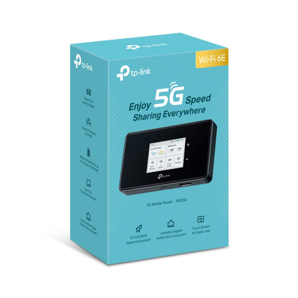 TP-Link M8550 5G mobile hotspot resting on a coffee shop desk, providing fast wireless internet to a nearby laptop and smartphone.