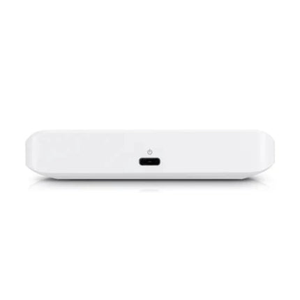 A clean desktop deployment of the fanless UniFi Flex Mini switch, showing neat cable paths running into its five full line-rate gigabit RJ45 slots.