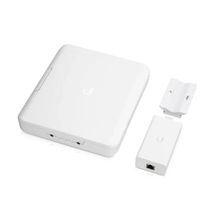 Bottom section close-up of the Ubiquiti USW-Flex-Utility enclosure showcasing rubberized weatherproof cable entry pathways, ethernet passthrough glands, and the main power knockout port.